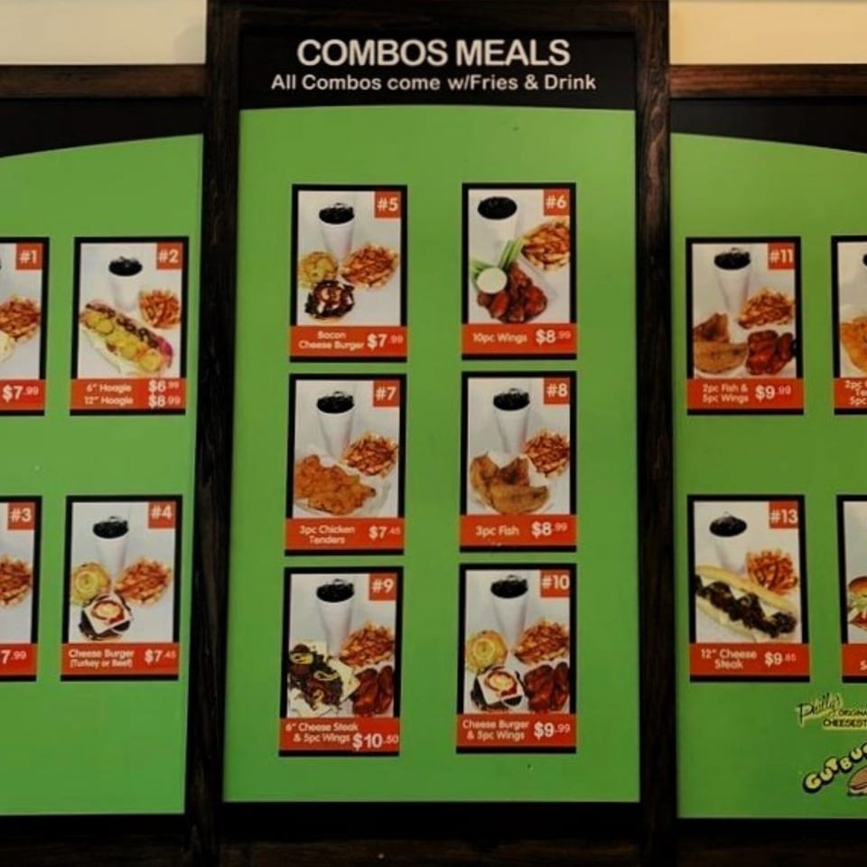 A menu board displays various Gutbusters Breakfast combo meals with fries and drinks.
