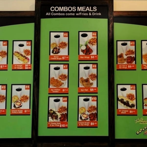 A menu board displaying various Gutbusters Breakfast combo meals with fries and a drink.