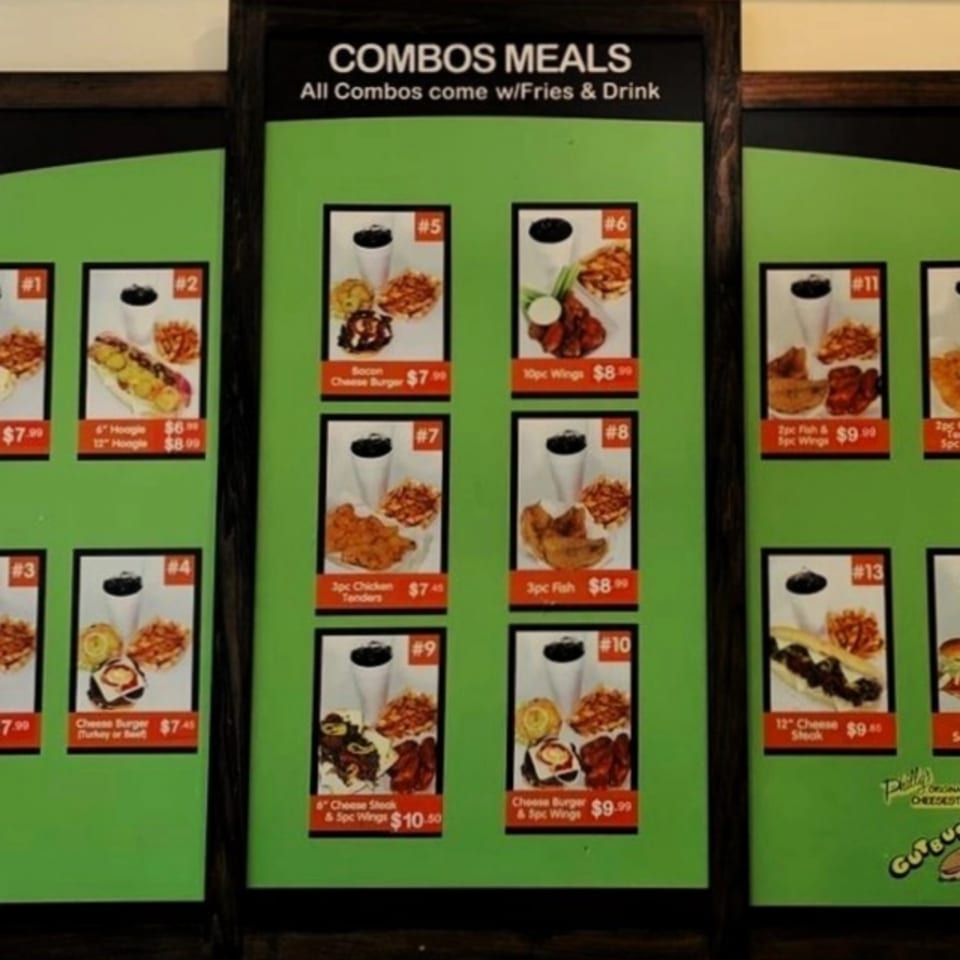 A menu board displaying various Gutbusters Breakfast combo meals with fries and a drink.